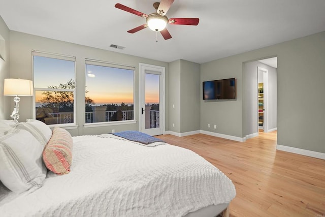 bedroom featuring a ceiling fan, baseboards, visible vents, access to outside, and light wood-type flooring