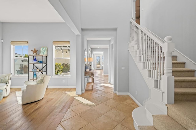 entrance foyer featuring stairs, baseboards, and light wood finished floors