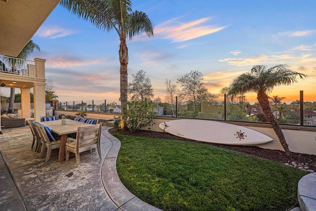 view of yard featuring a balcony, outdoor dining space, and a patio area