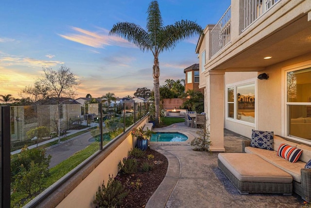 view of patio featuring a balcony, fence, and a fenced in pool