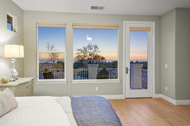 bedroom with visible vents, baseboards, and wood finished floors