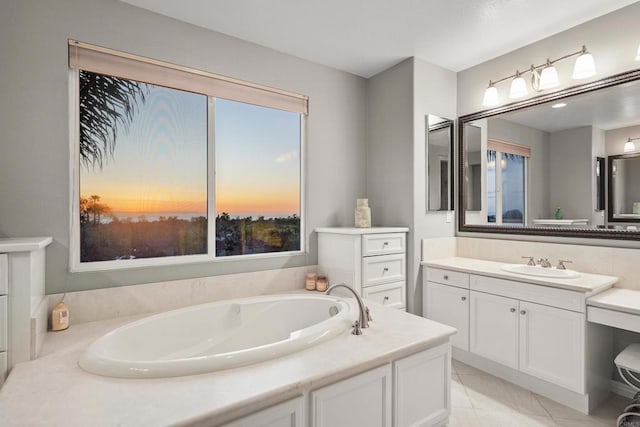 full bath with a garden tub, vanity, and tile patterned flooring