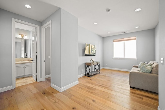 sitting room with recessed lighting, light wood-type flooring, baseboards, and visible vents