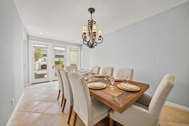 dining room featuring light tile patterned floors, baseboards, and an inviting chandelier