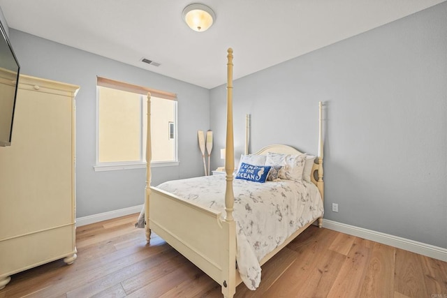 bedroom with light wood-type flooring, visible vents, and baseboards