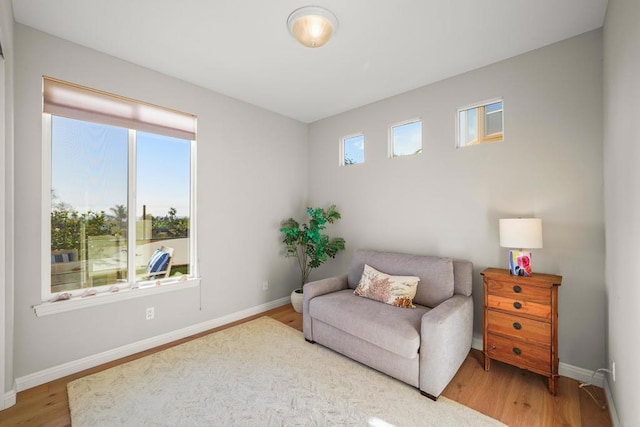 sitting room with a wealth of natural light, baseboards, and wood finished floors