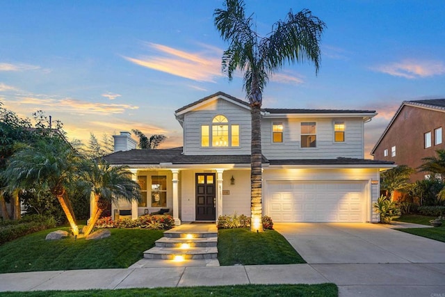 traditional home featuring a yard, driveway, and a garage