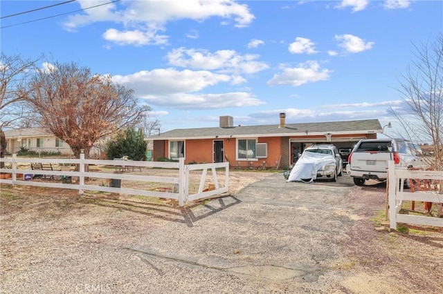 ranch-style house featuring a fenced front yard and driveway