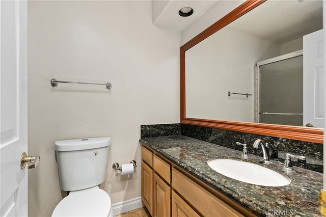 bathroom with a shower with shower door, toilet, and vanity