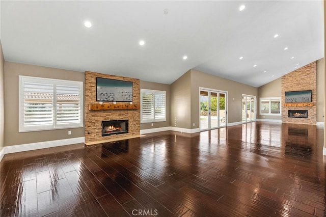 unfurnished living room with a stone fireplace, wood finished floors, and baseboards