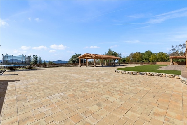 view of patio featuring a gazebo, a trampoline, and fence