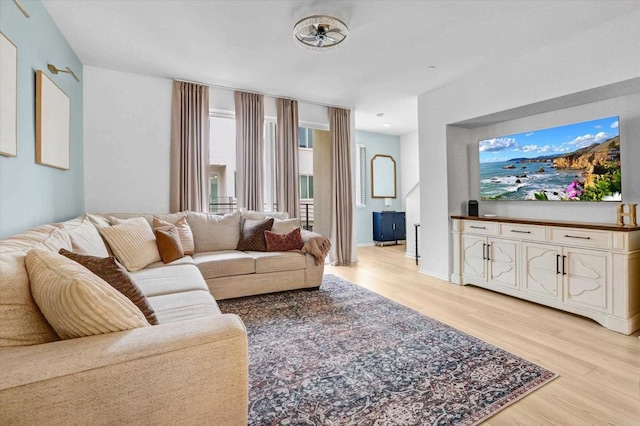 living area with light wood-style flooring and baseboards