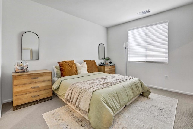 bedroom featuring baseboards, visible vents, and light carpet