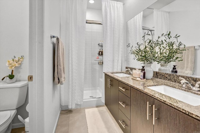 full bathroom featuring tile patterned floors, toilet, a stall shower, and a sink