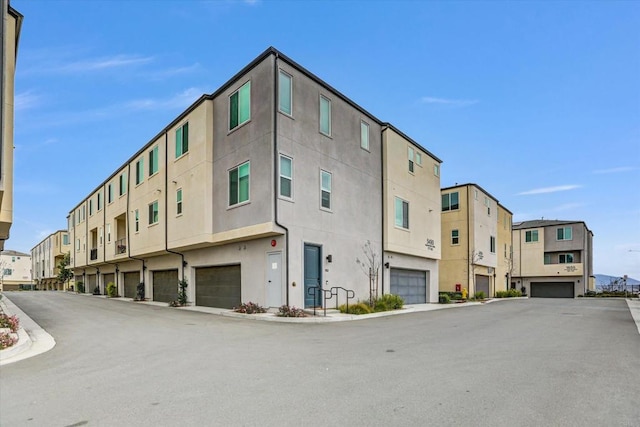 view of property featuring a residential view and an attached garage