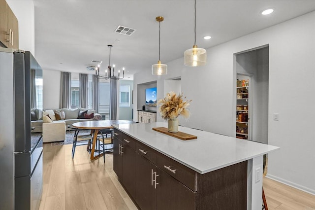 kitchen featuring light wood finished floors, visible vents, light countertops, and freestanding refrigerator