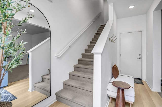 staircase with recessed lighting and wood finished floors