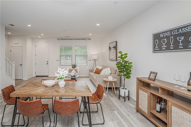 dining room with visible vents, baseboards, recessed lighting, stairs, and light wood-style floors