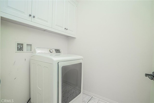 laundry room with cabinet space, washer / dryer, marble finish floor, and baseboards