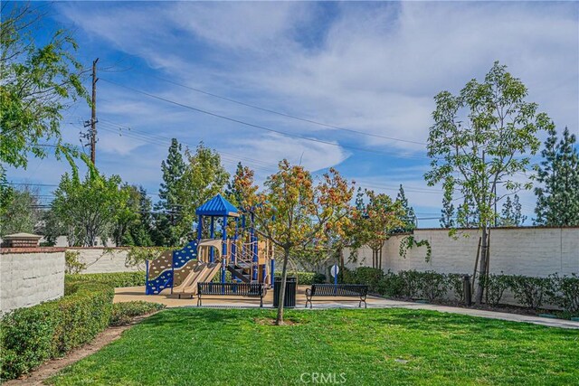 community playground featuring a yard and fence