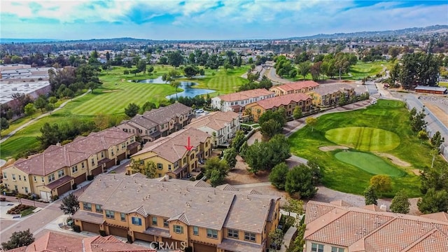 drone / aerial view featuring a residential view, golf course view, and a water view