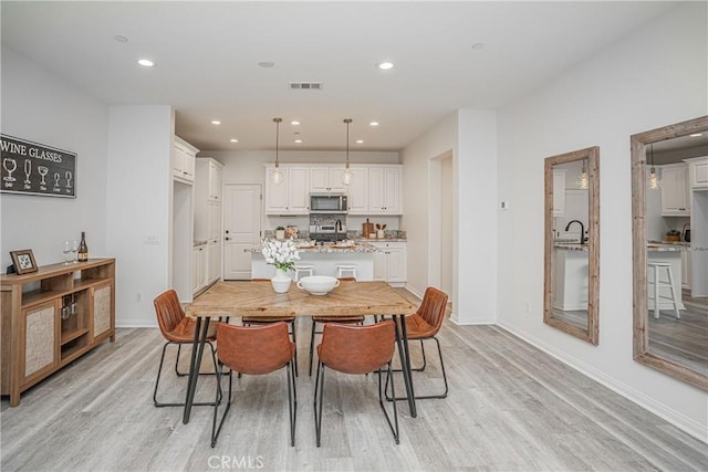 dining area with visible vents, recessed lighting, light wood-type flooring, and baseboards