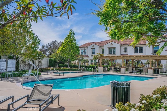 pool with a patio area and fence