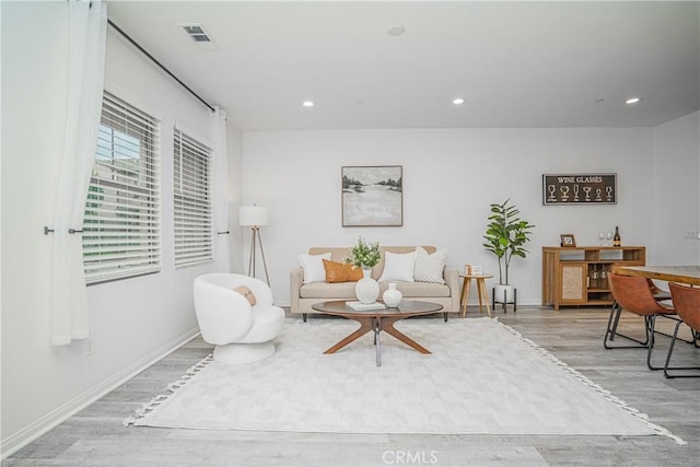 living area with visible vents, recessed lighting, baseboards, and wood finished floors