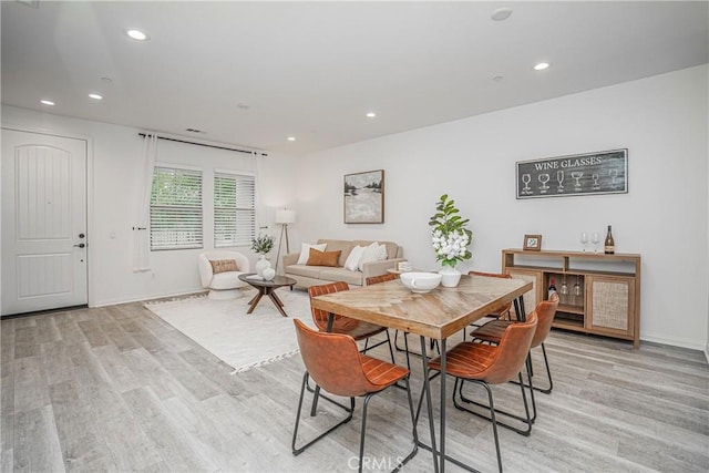 dining room with light wood-style flooring, recessed lighting, and baseboards