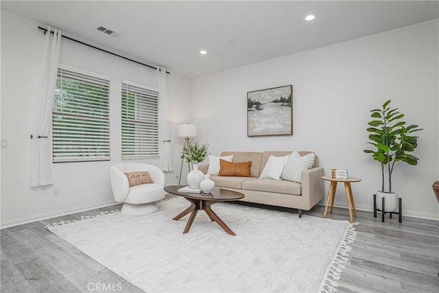 living area featuring recessed lighting, visible vents, and wood finished floors