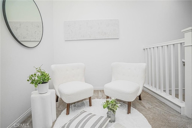 living area featuring baseboards and carpet