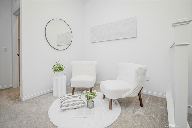 living area featuring baseboards and carpet