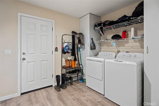 laundry room featuring laundry area, washer and dryer, light wood-style flooring, and baseboards