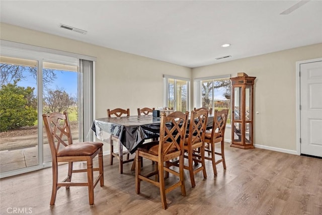 dining area featuring visible vents, plenty of natural light, and light wood-style floors