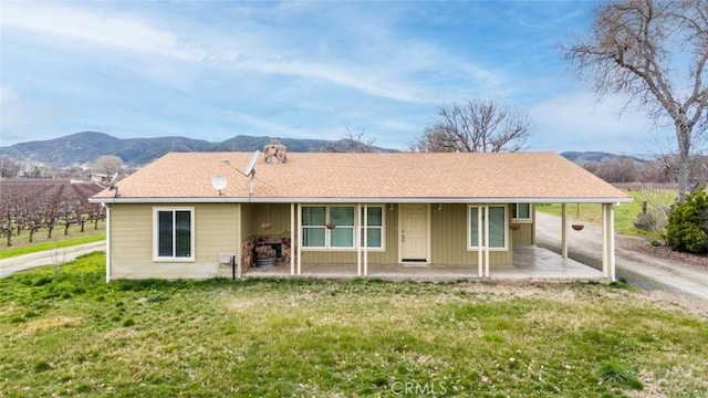 view of front of house with a mountain view and a front lawn