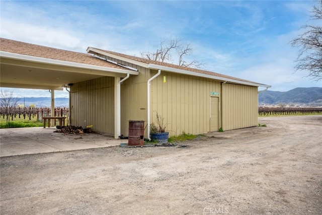 view of home's exterior featuring a mountain view and a shingled roof