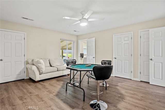 game room with visible vents, a ceiling fan, baseboards, and wood finished floors