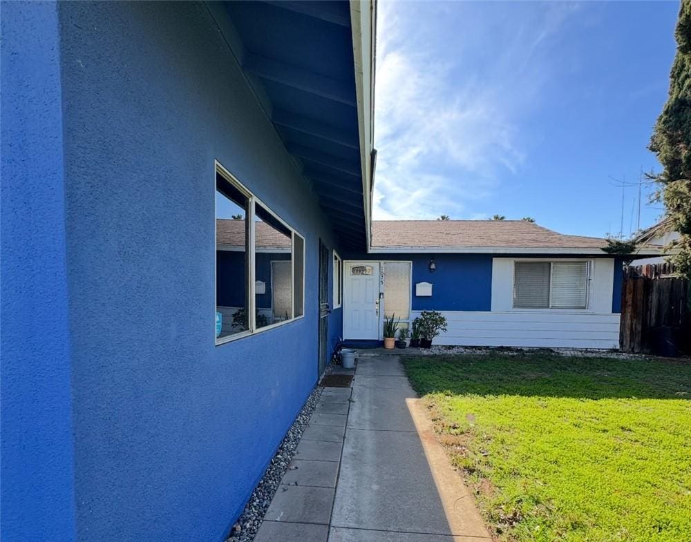 view of front facade with stucco siding and a front yard