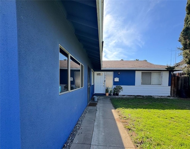 view of front facade with stucco siding and a front yard