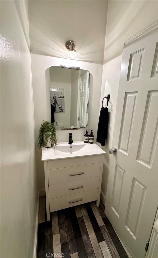 bathroom featuring vanity, baseboards, and wood finished floors