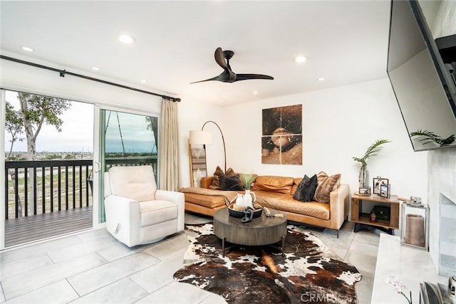 living area with tile patterned floors, recessed lighting, a high end fireplace, and ceiling fan