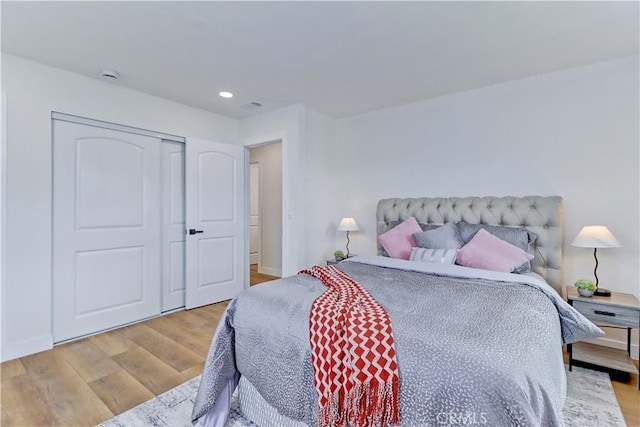 bedroom featuring a closet, recessed lighting, baseboards, and wood finished floors