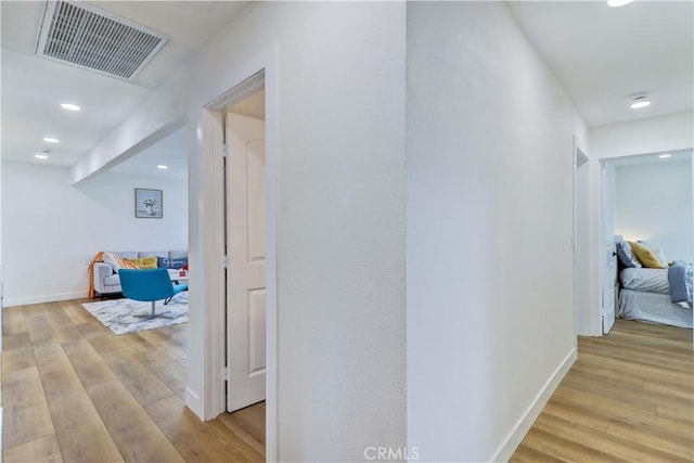 hall featuring light wood-style flooring, recessed lighting, baseboards, and visible vents