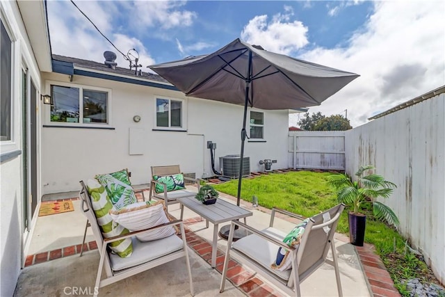 view of patio featuring central AC unit, outdoor lounge area, and a fenced backyard