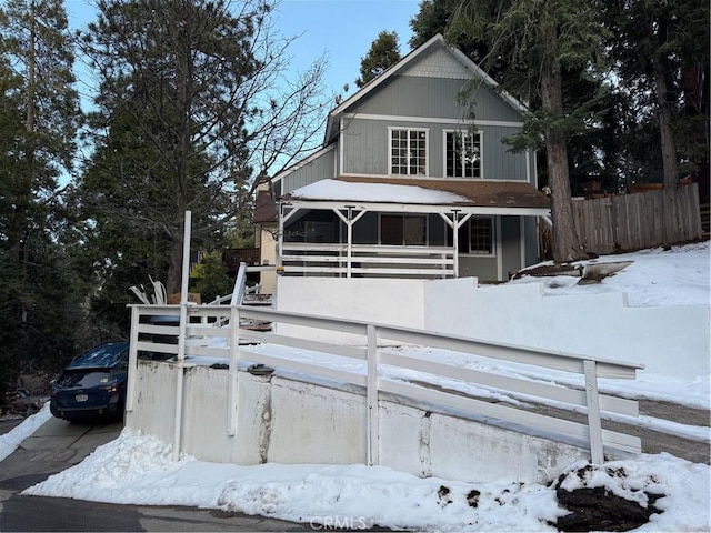 view of front of property with a porch and fence