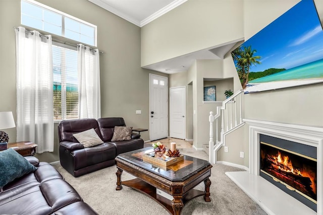 living room with baseboards, stairs, ornamental molding, carpet flooring, and a glass covered fireplace