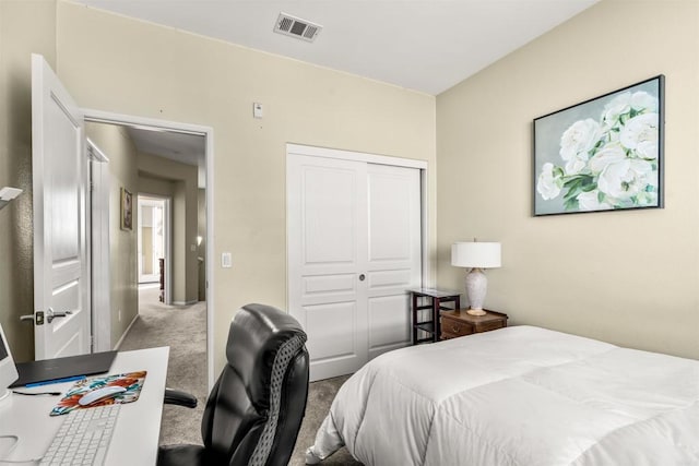 carpeted bedroom featuring visible vents and a closet