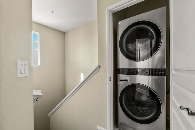 clothes washing area featuring laundry area and stacked washer / dryer