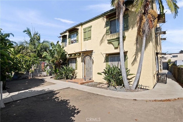 view of property with fence and stucco siding