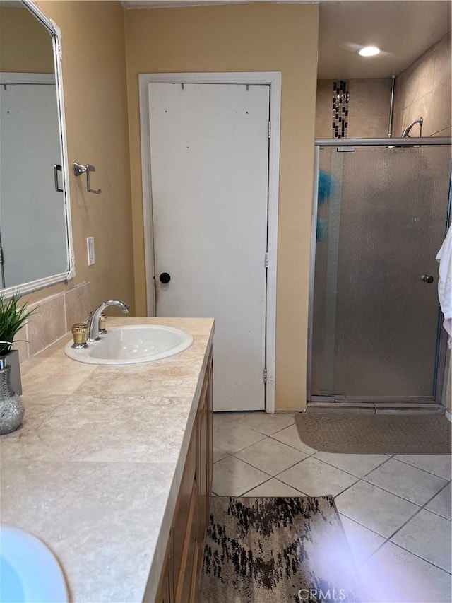 bathroom featuring tile patterned floors, a shower stall, and vanity